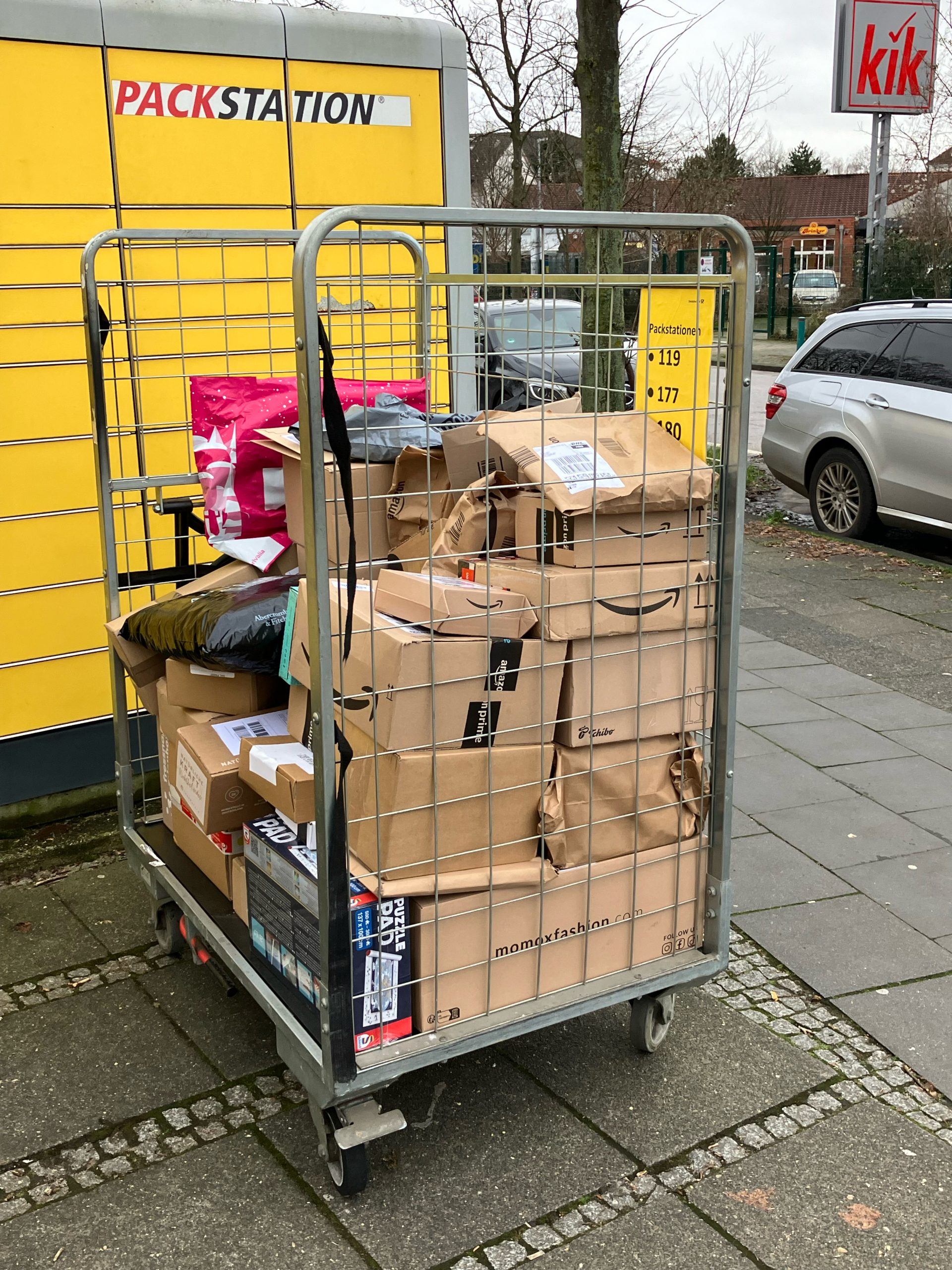 Eine Gitterbox voller Pakete, unbeaufsichtigt vor der Hauptpost in Duisburg