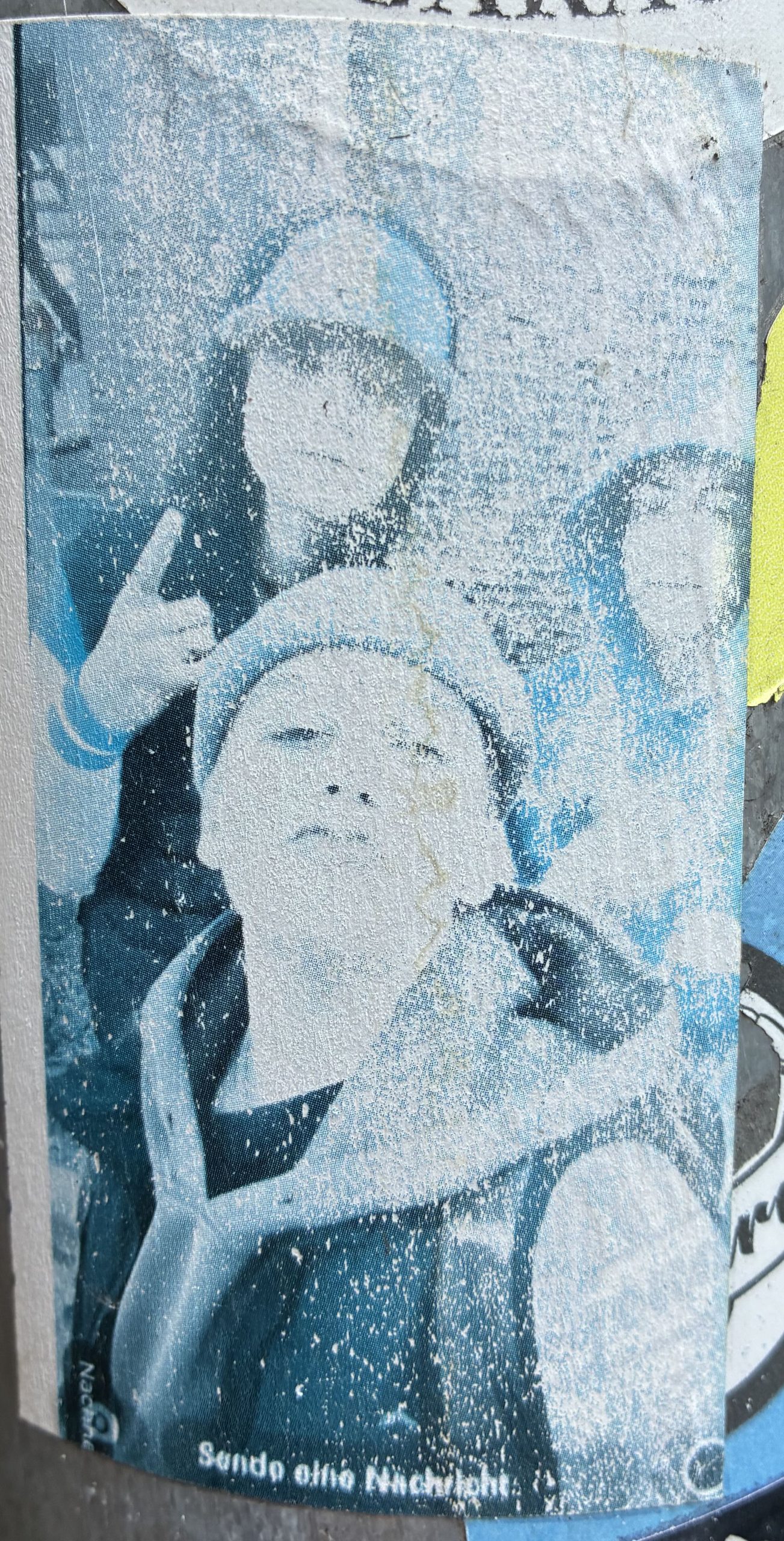 Hochformatiger, verblasster Sticker mit grobkörnigem Druck. Zu sehen sind drei junge Personen dicht beieinander, eine vorne mit ausgestreckter Hand, zwei dahinter, eine zeigt ein Handzeichen. Unten ist ein kleiner Schriftzug erkennbar, jedoch kaum lesbar. Der Aufkleber wirkt stark verwittert und fleckig. Unten steht: „Sende eine Nachricht“